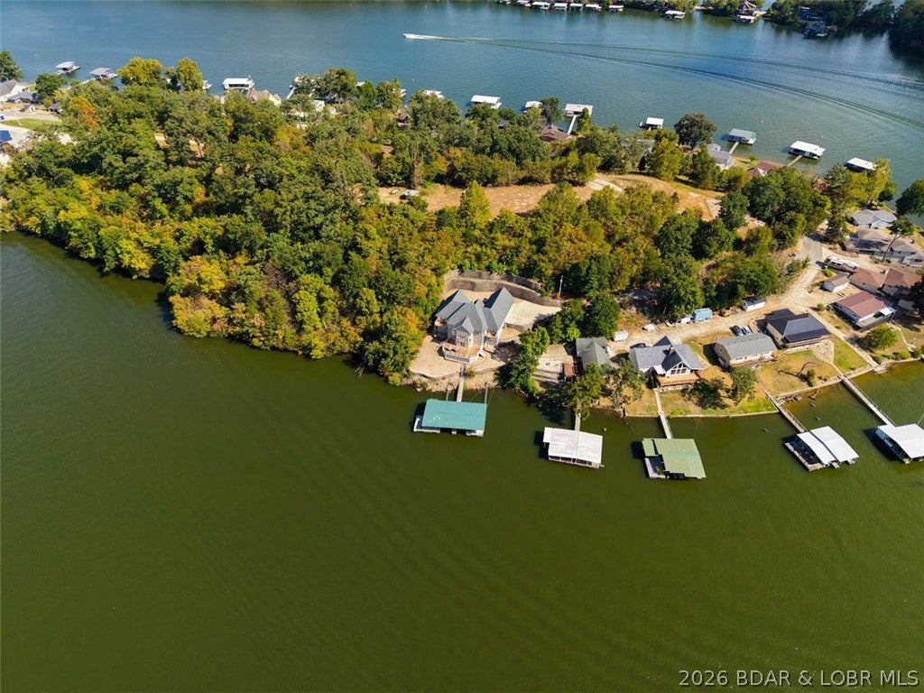 Lakefront Privacy, Income Potential & Room to Grow! Welcome to your Lake of the Ozarks retreat tucked away at the end of a peaceful cul-de-sac on the quieter waters of the Little Niangua Arm. This impressive 2.5-level lakefront home offers 6 bedrooms, spacious living areas, vaulted ceilings, and plenty of room for family and guests to spread out and enjoy lake life. A 3-car garage provides ample space for vehicles, lake toys, and storage, while the 2-well concrete dock makes getting out on the water easy. Adding even more value, the property includes two additional lakefront lots, creating a rare opportunity to preserve your privacy, expand the existing property, create a family compound, or grow your vacation rental portfolio. The home is being sold turn-key, making it an easy transition for someone looking to continue the established nightly rental operation or simply walk in and start enjoying lake living from day one. With lakefront privacy, expansive living space, a 3-car garage, concrete dock, additional acreage, and income potential, this is more than a lake house — it's an opportunity to create the lake lifestyle and investment you've been looking for.