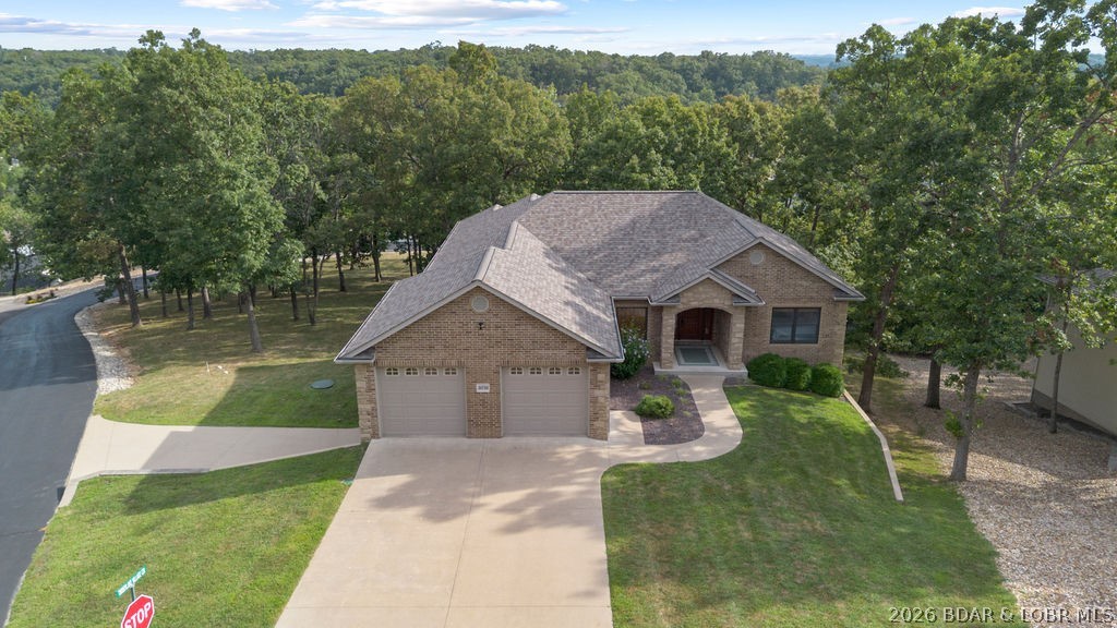 Luxury, lake views, and room to grow—welcome to Timberlake Village Estates! This custom-built, all-brick beauty sits on 3 estate-sized lots (buildable per subdivision rules) and includes a 12x32 boat slip in the community dock. Enjoy main-level living with an open floor plan, hickory hardwoods, hickory cabinets, and a chef’s kitchen with granite/quartz counters, custom cabinetry, and stainless appliances. The Owner’s Suite offers dual sinks and a walk-in tiled shower with dual heads. A screened, covered deck captures stunning lake views, while the lower level is built for entertaining with a wet bar, family room, flex spaces, storage galore, and a storm shelter. Car lovers will appreciate 4 car garage and low-maintenance concrete decks. Community perks include a pool, clubhouse, playground, and lakeside dock with no stairs. Impeccable craftsmanship, endless possibilities with the extra lots, and an unbeatable lake lifestyle—this property is a rare find!