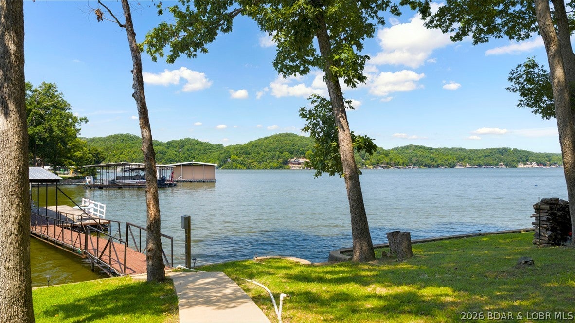 Double lakefront lot with 160 ft of shoreline, big open views, calm water, & a gentle, usable lot! This 4+ bedroom home offers the flexibility for full-time living, a vacation retreat, or an income-producing rental. Plenty of parking makes hosting friends, family, or guests easy. The spacious 2-car garage features an above 12x48' finished bonus room—perfect for bunk room, an office, guest quarters, or man cave—plus an another 336 sq ft storage area. A detached 20x20 single car garage offers even more room for storage, workshop, or your favorite "toys". A 10x14' storage shed w electric provides space for tools & gardening supplies, while the fenced garden produces vegetables & herbs. Or make this storage shed a cool kids playhouse. Lakeside, a unique fish-cleaning station makes cleaning the day’s catch easy. The 3-well dock accommodates your pontoon, fishing, or ski boat. The property has been surveyed, providing added peace of mind about what you’re buying. If you want peaceful lakefront living, big views, easy topography, room for hobbies, & space for the people you love, 185 Jennifer Lane delivers. Grow memories, your portfolio, or the footprint of your lake home right here.
