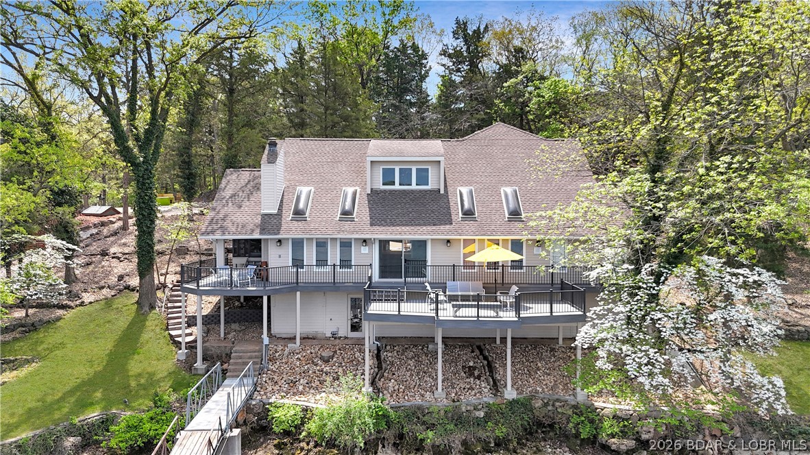 What a cool home! Oozing with character and charm, this home has been in the same family for 40 years, a first clue you have found a WINNER. Entry on the main level greets you with a Blow Your Mind View. Six steps down to the massive great room with the cutest little conversation pit (aka The Love Pit) surrounding the wood burning fireplace. Overlooking the great room is the fully remodeled eat in kitchen with tons of storage, all newer stainless appliances and granite surfaces plus a formal dining space. Darling screened porch walks right out to the newer composite decks with aluminum railings. Primary suite walks out to a more private deck area and features an oversize whirl tub plus double vanity and walk in closet. Three guest suites include a beautiful 20x24 addition with full bath and walkin closet that sleeps a bunch - let the kids invite their friends. Tucked away from the main channel & heavy traffic, sun and swim time on the two well dock is the weekend hangout spot. Lots of storage and garden room below deck. Other fine features: hickory floors with polyurethane finish, skylights, wood ceilings in primary suite and kitchen, updated baths, partially furnished.