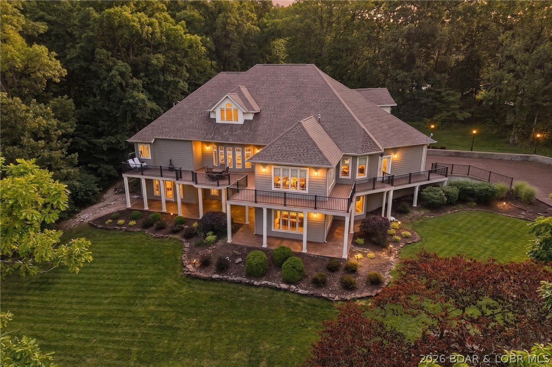 Nestled on a beautifully landscaped 1.3+ acre lot in the prestigious Old Kinderhook community, this exceptional custom estate offers 6,326 sq. ft. of luxury living with privacy and timeless elegance. Featuring 5 spacious bedrooms, each with a private ensuite bath, plus 7 total bathrooms, this home was designed for both comfortable living and entertaining. One of the bedrooms is currently being used as a home gym, offering flexibility to fit your lifestyle. The expansive floor plan includes a dedicated office, family room, media room, and bar area perfect for hosting guests. The luxurious primary suite is a private retreat with an attached sitting room. High-end finishes and custom details are showcased throughout. Arrive in style via the stunning stamped and stained concrete circular driveway, and enjoy the convenience of an oversized 4-car garage. Surrounded by mature trees, manicured landscaping, and a peaceful park-like setting, this remarkable property offers luxury living in one of Lake of the Ozarks premier golf course communities.