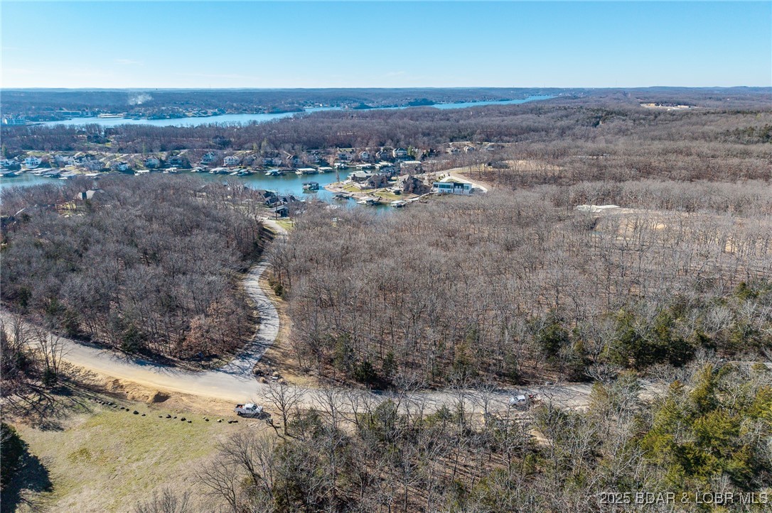 Surrounded by mature trees and natural Ozarks beauty, this wooded lot at The Villages at Shawnee Bend offers a peaceful, private setting within one of Lake of the Ozarks’ most distinguished communities. From the moment you arrive through the grand waterfall entrance, the neighborhood’s upscale character is clear. Residents enjoy access to a beautifully appointed clubhouse, resort-style community pool, championship tennis courts, and pickleball facilities, along with parks, and playgrounds. Paved roads and underground utilities make building seamless while preserving the natural landscape. Ideal for a custom home or lake retreat, this wooded homesite blends serenity, luxury, and an active lake lifestyle.