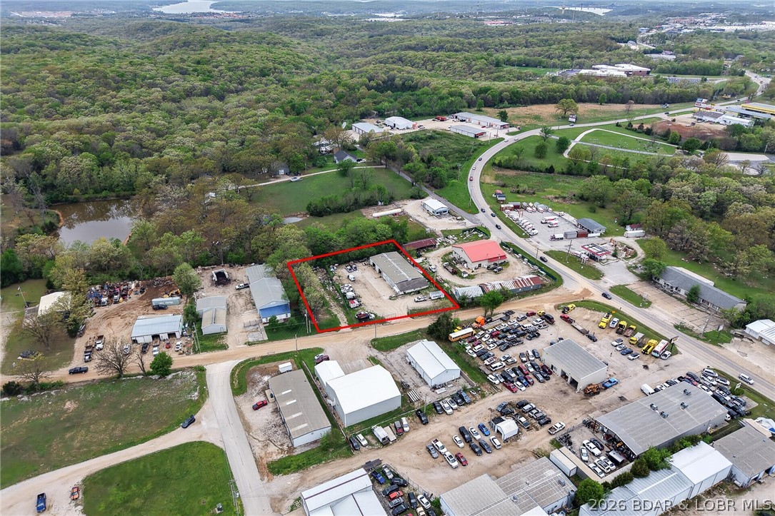 Absolutely fabulous location! Situated just off Highway 42, this versatile commercial property offers outstanding accessibility while still being within Osage Beach city limits. Set on a large, fenced lot, the approximately 5,600 sq ft building is designed to accommodate a wide range of uses. It features two large bays plus an additional heated bay, making it ideal for service, storage, or light industrial needs. Inside, you'll find a full kitchen area, 2.5 bathrooms, and seven separate office spaces which is perfect for operations that require both workspace and administrative areas. A spacious loft adds even more flexibility for storage or expansion. The property also offers ample parking and is zoned C-1, opening the door to numerous business opportunities. City water and sewer provide added convenience and reliability. Whether you're expanding, relocating, or investing, this property checks all the boxes for location, functionality, and potential.