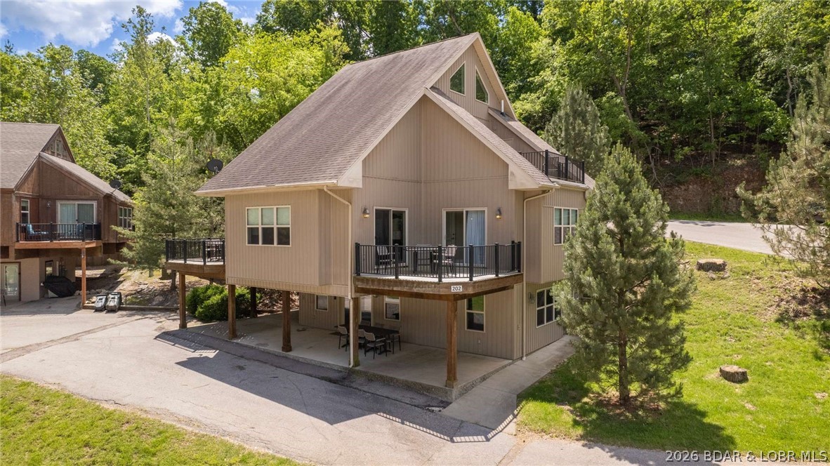 Amazing opportunity to own a unique lake-area property offering lakefront benefits with minimal maintenance. This versatile home sleeps up to 14 and features multiple lock-out options, allowing up to three separate rental spaces simultaneously. The main level includes living, dining, kitchen, full bath, and a lock-out primary suite. Upstairs offers a spacious bunk room with full bath, while the lower level functions as a private apartment with kitchen, living area, and bedroom suite — easily separated or opened to the main home. Community amenities include a sandy lakefront beach, sand volleyball court, swimming pool, and boat slips available for lease. Enjoy a popular restaurant just a short walk away and an unbeatable location at the top of the Legendary Bagnell Dam Strip, within walking distance to events, entertainment, and attractions. Priced to sell.