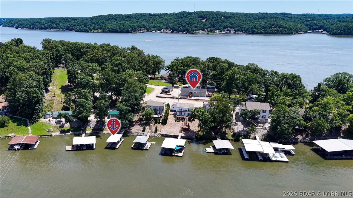 Welcome to lake life at its finest, and at a price that will genuinely surprise you! Nestled in the heart of a warm, welcoming community where golf carts outnumber cars and neighbors actually know each other's names, this charming 3-bedroom, 2-bath home is your ticket to everything the Lake of the Ozarks has to offer without the price tag you'd expect. Perched at the 30-mile marker in a deep-water, protected cove with stunning views of the 4 Corners area, this property checks every box: a lake view, your very own private dock with a swim platform just steps away, a private yard, a detached garage, and plenty of space for hosting. Inside, you'll find vaulted ceilings, luxury vinyl plank flooring, and a layout that feels clean, bright, and move-in ready from the moment you walk through the door. Step outside and you're minutes away from some of the lake's most beloved waterfront restaurants, including Papa Chubby's, Larrywood, Paradise, and Captain Ron's. Whether you're dreaming of a full-time lake home, a weekend escape, or a smart investment in a community people fall in love with and never leave, 965 Four Waters Drive in Sunrise Beach is the rare find that makes it all possible.