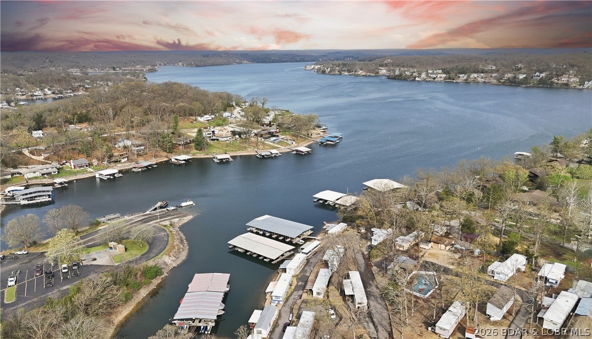 Here is a vacation home just steps from the water, with a nice view of the cove and the main channel, at a great price! A 2-bedroom, 1-bath mobile home in a great location by water and land. Located at the 11 MM right across from the Shawnee Bend Public Boat Ramp. The owner loves fishing and sitting on the large covered deck looking at the lake and listening to all of the birds in the morning. There is a swim dock, a swimming pool, and a 9x24 covered boat slip. No rentals are allowed. The mobile home is on leased land with a monthly assessment. The home has central air and heat and newer flooring. Small storage shed on the side and large blacktop parking area next to home. Worth the purchase for the covered boat slip alone, which could cost anywhere between $ 300 and $ 500 per month. This is a great value, schedule your showing today and start living the lake life.