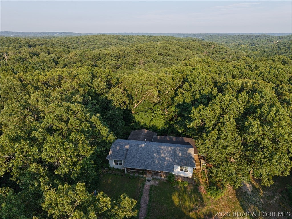 Privacy, acreage, and endless possibilities! Tucked away at the end of an almost ¼-mile private driveway, this move-in-ready property sits on 97 wooded acres just minutes from the lake. With abundant wildlife and plenty of room to explore, hunt, hike, or ride, it’s an ideal Ozarks retreat. The 3-bedroom, 3-bath manufactured home also includes 2 non-conforming rooms for guests, an office, or hobbies. The open layout features a spacious living room with wood-burning stove, eat-in kitchen, main-level laundry, and a generous primary suite with private bath, ample closet space, and deck access. The partially finished walkout basement offers a second living area with bar, full bath, and additional space ready to finish. Outside, an oversized 2-car attached garage and 30x40 pull-through shop with concrete floors and electricity provide plenty of room for equipment, projects, boats, and lake toys. Whether you’re looking for a full-time home, hunting property, or recreational getaway, this 97-acre property is ready for your next adventure!