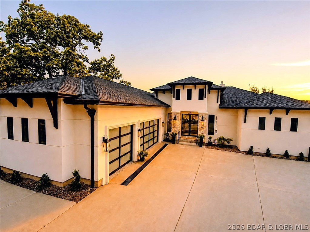 THIS is what luxury new construction at Lake of the Ozarks should look like. Perfectly positioned in a cove with main channel views at the Osage 15MM in the prestigious Porto Cima community, this custom lakeside estate delivers true resort-style living. The outdoor space is stunning—featuring a heated gunite pool w/ tanning shelf, stamped concrete decking, see-through gas fireplace & covered cabana with grill station; all surrounded by extensive, professionally designed landscaping with illuminated stonework along the 105' of shoreline, creating a striking floating effect. Inside, the living room showcases 16' high ceilings w/ an expansive quad-panel stacking glass door system, seamlessly blending indoor & outdoor living. The kitchen impresses w/ layered accent lighting throughout, custom cabinetry, quartz countertops, warming drawer, pot filler & even double dishwashers! The lower level includes a 6-sided concrete safe room ideal for a shelter, wine cellar or gun room. Additional highlights FULLY furnished, epoxy garage floor & pool bath floor, gentle driveway + additional parking. Premier location by land & water near golf, dining, entertainment, shopping & quick highway access.