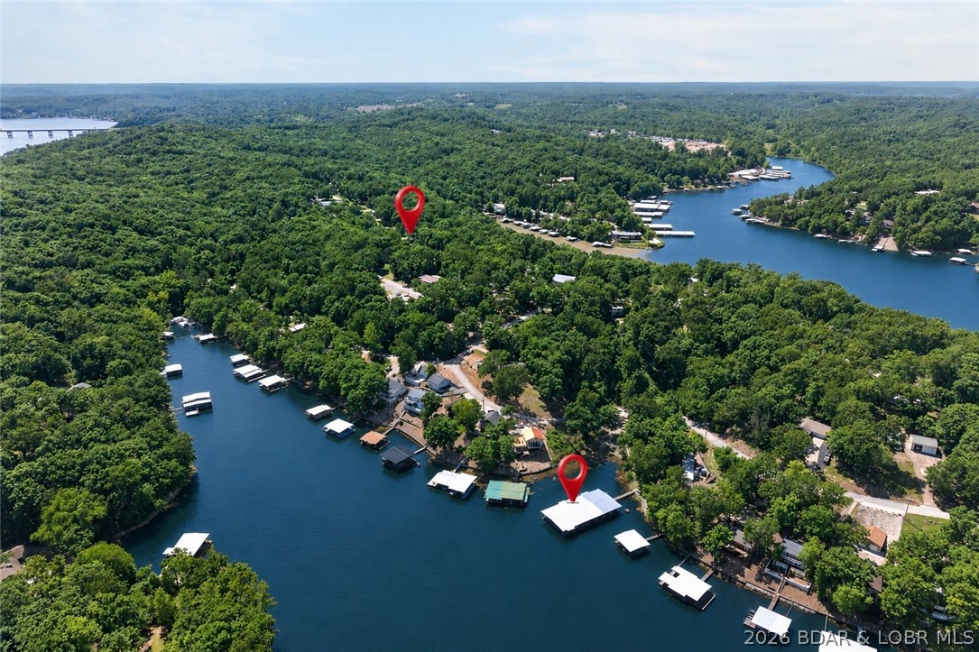 There is something easier about lake life when the boat slip, the garage, and the house are all in one place. This updated 3 bedroom, 2 bathroom home was rebuilt with long-term comfort, efficiency, and future flexibility in mind — and from the moment you walk in, it feels like you already belong here. Updated flooring, paint, siding, and major improvements throughout mean the work is done and the only thing left is to enjoy it. Inside, an additional living space with its own wet bar and bathroom gives everyone room to spread out — whether that becomes a second family room, a bunk room, a game room, or the spot nobody ever wants to leave. The detached two car garage handles the lake toys, ATVs, and everything else that comes with living this kind of life. Down at the community dock your 10x24 slip is ready whenever you are, with boat ramp access, trailer parking, and space for ATVs and golf carts right by the water. Early morning fishing trips. Sunset cruises. Weekends that actually feel like weekends. This is the kind of place you stop visiting and start coming home to.