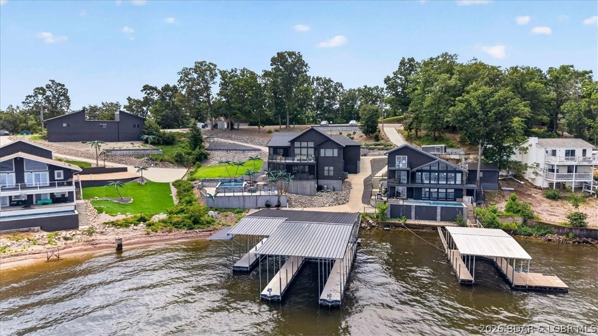 Experience elevated lakefront living in the heart of Lake of the Ozarks. Built in 2019, this contemporary home perfectly balances the benefits of newer construction with a premier Horseshoe Bend location, offering effortless access to the Lake's premier restaurants and entertainment by both land and water. The property sits on a large lot with plenty of parking and boasts breathtaking main channel views alongside a spacious dock designed for effortless gatherings, and easy lake access. Inside, you will find an expansive entertainment area and a dedicated movie room, while the seamless indoor-outdoor flow creates a vibrant atmosphere for hosting. Currently a successful income-producing rental, this versatile property represents a high-performing investment opportunity as well as a luxurious personal sanctuary. Whether you are looking for a weekend getaway, a full-time residence, or a strategic addition to your portfolio. Step in and experience the perfect blend of luxury and leisure, your dream lakefront lifestyle is waiting.