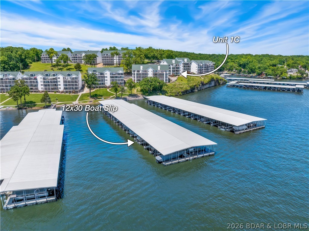MOTIVATED SELLER *** An outstanding nightly rental, investment with an ROI of $87,000 annually, or family lakefront retreat!**** Turnkey lakefront luxury awaits in this fully furnished, remodeled, first-floor 6-bedroom, 4-bath condo at Lake of the Ozarks. The chef-style kitchen features a granite waterfall island, two refrigerators, pantry, updated cabinetry, modern appliances, and ample entertaining space. The single-level layout includes two primary suites with deck access and lake views. Spa-inspired bathrooms offer floating vanities, three walk-in showers, and a tub/shower combination. Enjoy the oversized deck overlooking green space and your 12x30 boat slip. Set on a quieter arm of the lake, it’s ideal for boating, fishing, kayaking, and coving out. Amenities include a pool, clubhouse, fitness area, playground, and firepit.