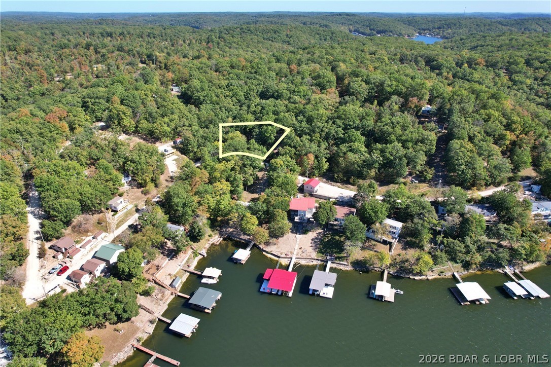 Lakeview Lot on Marina Lane – Perfect for Building or Camping!  Discover your own slice of Lake of the Ozarks paradise with this beautiful second-tier lot located at 27261 Marina Lane. Enjoy stunning seasonal lake views, mature shade trees, and the peaceful setting of lakeside living—all without the waterfront price.  Some excavating has already been done including some gravel and leveling, making it easier to start your dream lake home or create the perfect camping getaway. Whether you're looking to build or just enjoy weekends away, this lot offers flexibility and potential.  Located just 10 miles from town, you'll love the convenience of nearby shopping, dining, and entertainment, while still enjoying quick access to the lake’s best amenities—boating, fishing, swimming, and camping are all just minutes away.  Don’t miss this opportunity to own a piece of the Ozarks. Your lake adventure starts here!