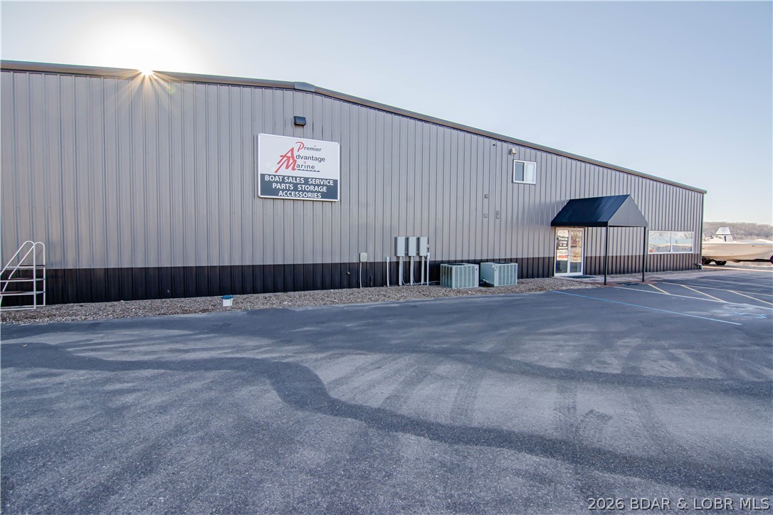 High-visibility commercial opportunity in Sunrise Beach just minutes from Laurie, featuring 512’ of Hwy 5 frontage and exceptional exposure in one of Lake of the Ozarks’ busiest corridors. This expansive 16,000± SF facility (plus mezzanine) serves as the a highway retail and service location and operates in tandem with their waterfront marina less than 5 minutes away. Properties may be purchased together or separately, offering flexibility for investors or owner/operators. The building includes showroom, parts department, multiple offices, & a massive 8-stall service shop with room for expansion. New asphalt parking lot provides ample space for boats, trailers, & customer parking. Known as a major boating supply destination, the store generates strong merchandise and parts sales while servicing boats from both ends of the lake, aided by nearby ramp access at the 8MM.  Designed for efficiency and scale, this location allows full-service operations under one roof with outstanding highway presence and steady traffic. Acquire a proven, high-volume commercial asset in the heart of Missouri’s premier recreational market!  Building is in great shape and could easily be repurposed.