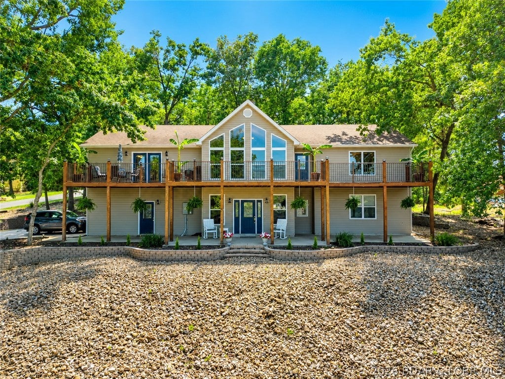 LAKE VIEWS FOR MILES! This custom-built home offers an incredible location by both land & water, w/ stunning lake views enjoyed from the covered porch, open deck, & multiple outdoor spaces. On holiday weekends, relax & enjoy the fireworks show from The Lodge. The open-concept main level features a spacious great room w/vaulted ceilings & fireplace, generous kitchen w/ large dining area that leads to the deck,huge walk-in pantry. Oversized laundry room provides abundant storage. Double French doors lead to the spacious primary suite, complete w/ custom walk-in closet. The primary bath features dual vanities, jetted tub, walk-in shower, & skylights. A second bedroom & full bath complete the main level. Impressive bonus room features a hot tub, fireplace, & two walk-out decks-perfect for gardening, outdoor gatherings-offers a great firepit area. The lower level offers an inviting family room w/custom bar, two additional bedrooms, full bath. An oversized two-car garage & oversized driveway provide ample parking. Located in Porto Cima-opportunity to enjoy the Country Club lifestyle, complete w/ Marina & also all of the Four Seasons Amenities included. Furnishings-included.