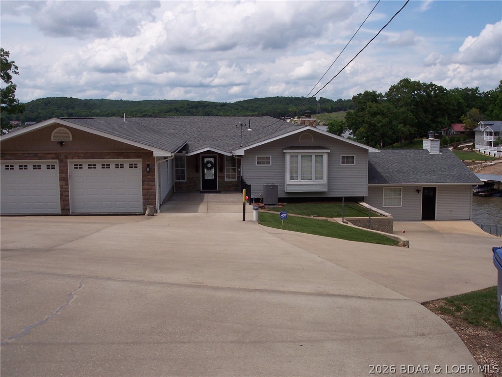 NEW PRICE- Seller has found their new forever home so new buyer  will get incredible main channel views of 31MM Lake of the Ozarks with cove location at an amazing price!  1.28 acres with 180' deep water lakefront.  4654 SQFT 4 BR/3 full bath home (4th BR non-conforming) includes upper & lower level kitchens and laundry.  There is also a huge family room/game room.  Sunroom with lots of west facing glass off of kitchen and dining area offer those amazing lake views and a huge deck just off of the sunroom makes for a perfect area for family.  Under the deck is a screened porch with more lakefront views.  Deep two car attached garage with plenty of storage area.  Back yard is completely fenced in for pets or little ones.  2 storage rooms under home for water toys, etc.  Home has been recently remodeled & shows pride of ownership.  Dock is a 2 well covered dock with 2 boat lifts. Slip sizes are 10x27 &  10x23.  Years invested in making this dock a great fishing spot. Natural stone seawall protects the shoreline of this beautiful lakefront home.  Newer HVAC system installed in the last 2 years.  Tons of parking for guests or large family.  Home is located on county-maintained asphalt.