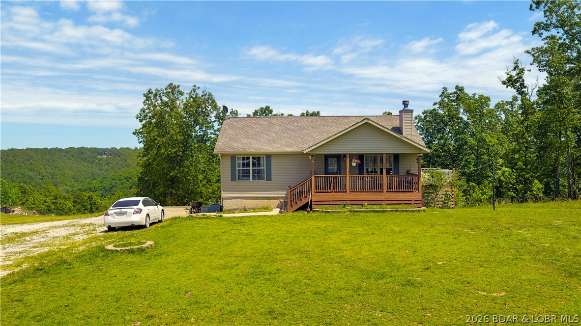 Situated on 16± acres in the rolling hills of Camdenton, this private country retreat offers sweeping countryside views, peaceful surroundings, and the laid-back lifestyle the Ozarks are known for. The secluded setting provides the perfect backdrop to relax, reconnect, and enjoy the beauty of rural living. The main level features an open living, kitchen, and dining layout with hardwood floors, stone fireplace, and access to both the covered front porch and side deck overlooking the countryside. You'll also find 3 bedrooms and a full bath on the main level. Downstairs, the private primary suite offers its own full bath and walk-in closet, along with an oversized family room currently used as office space, additional full bath, and spacious laundry/utility room. The lower level also provides direct access to the attached 3-car garage. Outside, the acreage is set up perfectly for hobby farming or horses with a horse stall, open pasture, and plenty of room to roam. The nine fenced acres is currently home to horses, chickens and goats. This property could be perfect for those looking to​​‌​​​​‌​‌​​​​‌​​‌​​​​‌‌ homestead!