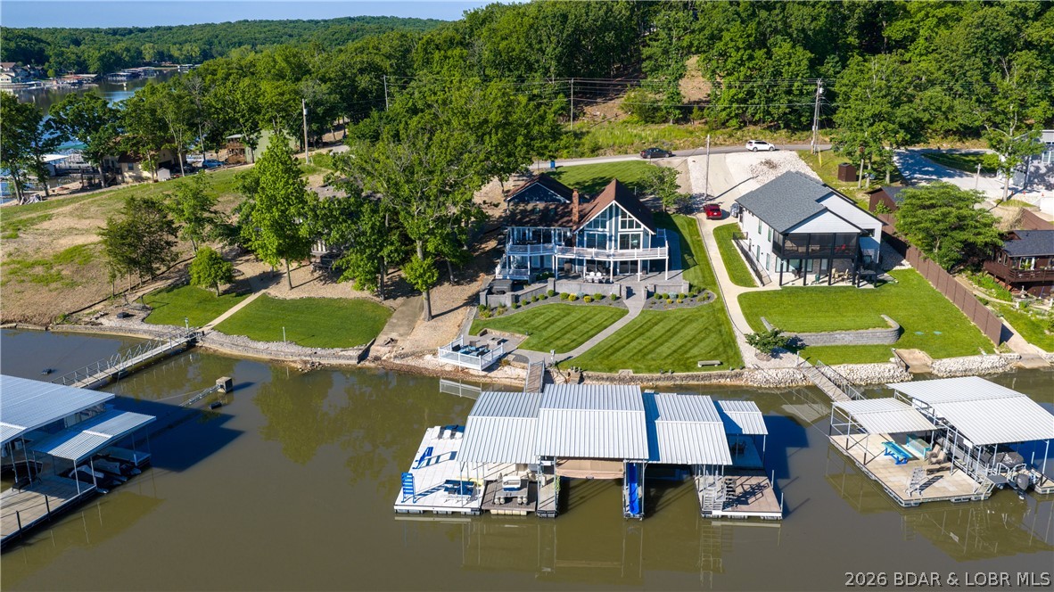 Updated lakefront home with proven short-term rental income potential at the 12MM in Sunrise Beach featuring cove protection with main channel views, a gentle lot, and easy access to the water. Recent improvements include fresh interior and exterior paint, updated kitchen and bathrooms, expanded dock improvements, and a custom waterfall feature alongside the home. Vaulted ceilings, multiple fireplaces, and spacious indoor/outdoor entertaining areas make this property ideal for full-time living, vacation use, or investment potential. The incredible concrete dock is designed for true lakefront entertaining with multiple slips/lifts, bar seating, kitchen space, and plenty of room to gather and enjoy life on the water. Conveniently located near the Porto Cima area with easy access to waterfront dining, entertainment, and boating by water or land. Existing rental history with additional upside potential. Current reservations to be honored after closing.