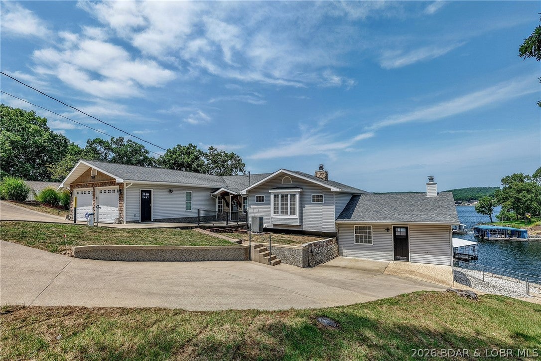 You won't believe the amount of parking - room for everyone inside and out. Sprawling floor plan allows everyone their own spaces on each level! The family room has a great kitchenette and access to an additional huge room that could be a guest apartment, wonderful home office/workout room - whatever your heart desires. Large screened porch off the family room is perfect for bug-less evenings. Washer and dryer on each level - no carting heavy loads up and down stairs. Expansive lake view from most rooms. Larger fenced lakeside yard, 180 feet of lakefront. Super location by road or water. This one has it all.