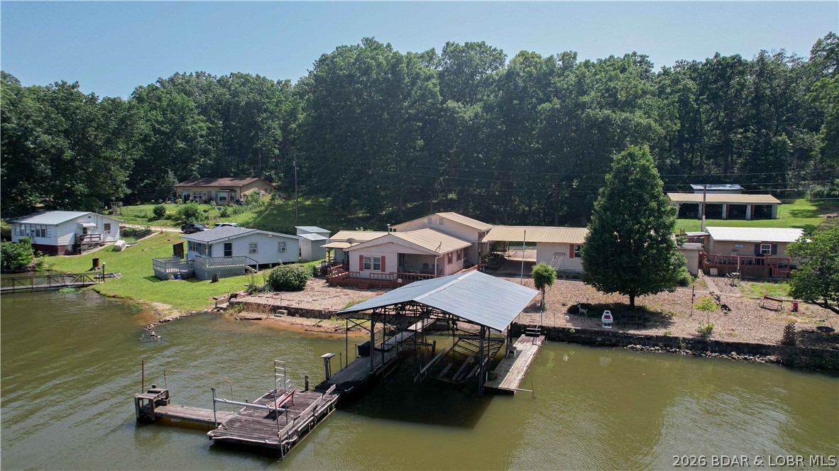 Lakefront home with Endless Potential! This 3-bedroom, 2-bath home offers approximately 100' of lakefront in a protected cove and is the perfect project for someone ready to make it their own.  Owned and loved by the same family for 60 years, this property is ready for its next chapter. A handyman's dream, the home needs TLC but offers a solid foundation for a full-time residence, weekend getaway, or investment. You'll appreciate the incredible storage and workspace with a 24'x36' detached 3-car garage plus a 24'x43' shed situated on the included 100'x100' lot across the road. Enjoy easy lake access from the private dock featuring unique boat lifts. If you've been searching for an affordable way to own lakefront property with room to add value, this is your chance. Bring your vision, your tools, and transform this hidden gem into the lake retreat you've always wanted.
