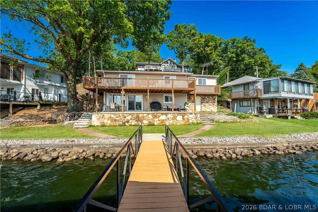 Lake life is supposed to be easy—and 100 Amber Rd understood the assignment. Located at the 34 MM in Sunrise Beach, this turn-key 3BR, 2.5BA waterfront home offers over 1,600 sq ft, a 1-car garage, over 75 ft of deep-water lakefront, gorgeous views, and something every lake buyer appreciates: relatively flat topography. Less hiking, more boating! Step down to the 2-well dock w/ 10x28 & 10x24 slips, boat lift, plus a PWC slip/lift. There's plenty of room for family, friends, & those guests who suddenly become very available once you own a lake house. Better yet, you’re positioned near some of the Lake’s favorite stops—Captain Ron’s, Fish & Company and Bear Bottom Resort are close by water, while Papa Chubby’s and Frankie & Louie’s are an easy trip by road. Morning coffee overlooking the lake, lunch by boat, then cruise home for sunset—this is how the Lake is meant to be enjoyed. Use it as a full-time home, weekend escape, or take advantage of its rental potential. Deep water, gentle terrain, great views, private dock, garage, rental potential AND a location that puts the fun within easy reach. Seawall has undergone a nearly complete remodel, completed in accordance with Ameren.