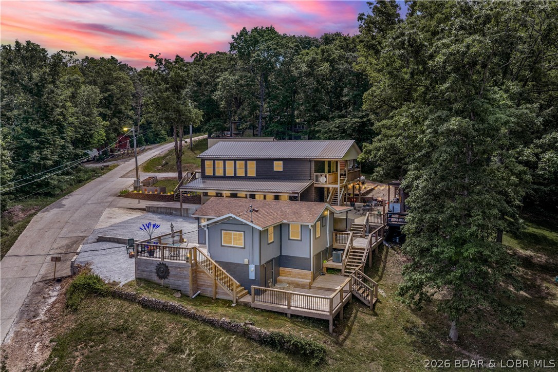 Lake-view property featuring a main residence(28251 Shore Rd), guest house(28243 Shore Rd.), finished heated metal building, greenhouse, storage building, & two-vehicle carport in a lake community with access to a community boat dock & boat launch.
The ranch-style main home offers a full finished walkout basement, open-concept living area, large windows with lake views, granite countertops, custom cabinetry, stainless steel appliances, & main-level laundry. The main level includes two bedrooms & two full bathrooms, including a primary suite with deck access & walk-in closet. The lower level provides additional living space with a second kitchen, bar area, third bedroom, full bathroom, & utility/storage space.
Outdoor features include upper & lower entertaining areas, patio, outdoor kitchen, firepit, & multiple lake-view seating. Additional improvements: finished, heated 24x32 metal building- flexible-use space, greenhouse, storage building, & carport.
 Additional Guest Home Information: 529 Sq Ft Finished, 778 sq ft Adjusted, 1 bedrm, 1 bathrm, Liv. Rm., Kitchen. Built1950. Updated 2025. 0.22 acres, Parcel ID 152003001005044000  New Septic system 2022, & Whole house generator.