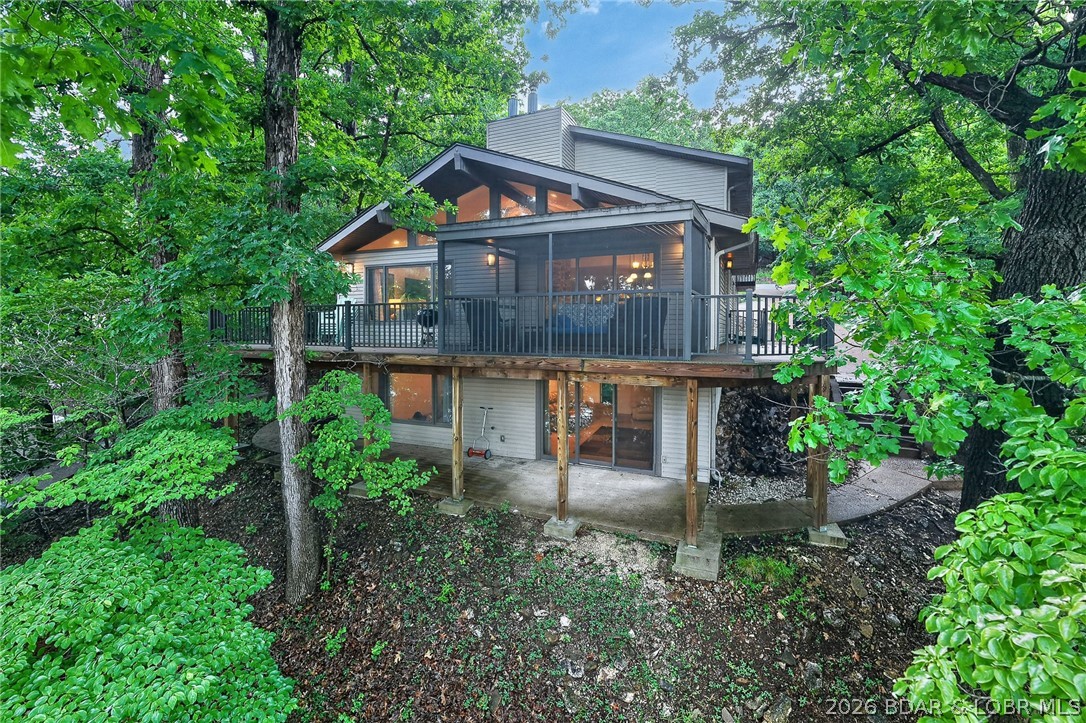 Experience the best of Lake of the Ozarks living in this impressive Horseshoe Bend waterfront retreat! Perfectly positioned at the 4MM in a desirable cove location with main channel views & deep water! This 5 bedroom (two are ensuite), 4.5 bath home offers over 4,184 sq ft of thoughtfully designed living space, Vaulted ceilings, multiple gathering areas w/3 living rooms, charming stone fireplace w/wood stove insert on main level, Lower level fireplace w/pellet stove insert, beautiful kitchen w/plenty of cabinet space, large walkin pantry, 2 dining areas, office, screened deck off of main living area w/trex decking, open deck area, sunroom and covered patio create the ideal setting for relaxing or entertaining after a day on the water. With 95 ft of lakefront, private dock, detached 2-car garage, great parking and strong vacation rental potential, this property checks every box for the ultimate lakefront lifestyle. Located in a GREAT Cove close to Dock Knockers! Just Hop on your boat and enjoy! Plus… if you don’t feel like taking steps to dock, there is a shared driveway with the neighbor that you can drive down to the lakefront .. perfect for a golf cart.