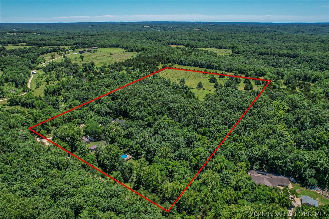 Are you looking for a peaceful setting close to the Lake of the Ozarks? You found it! Beautiful Property with 14+/- acres, 2 pastures (perfect for hobby farm), ATV trails. PLUS 2 Homes on the Property. Main Home features 1 Level Living(2795 sq ft), Open Floorplan, Vaulted Ceiling, Stunning Kitchen w/beautiful cabinets & tons of Counter Space, Butcher Block Island, Stainless Appliances, Pantry, Oversized Primary Suite w/2 walk in closets, Soaking tub & walk in tiled shower, covered patio off primary suite w/hot tub, 2 guest bedrooms-main level (1 is ensuite), Unfinished basement (can be used as 4th bedroom), Covered front deck-Large Patio off of the HUGE Dining room and 2 car attached Garage. Guest Home features- 800 sq ft, 2 bedrooms, 1 bath, Covered Deck, Open Living Room/Kitchen Area, 2 car carport and it comes Furnished! There is also a 30x40 Garage, Barn, outbuilding (perfect for parking your toys), fenced in Garden Area and a Swimming Pool w/Large Deck w/bar (so fun)! Definitely a Park Like Setting. New Roof on Main Home, Guest Home & Well House Fall of 2023. Located a few miles from the State Park = Boating, swimming, hiking & More! Property is not for rent.