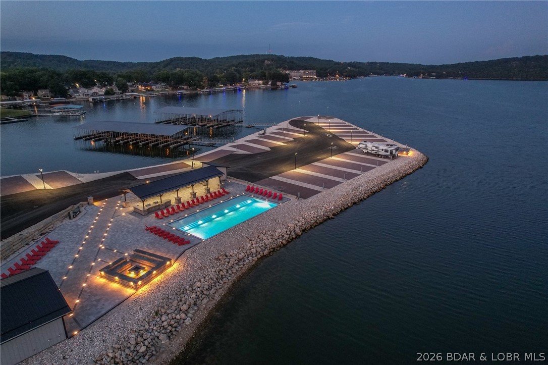 Welcome to Paradise Point RV Resort—one of the most exciting opportunities to own at the 38MM of Lake of the Ozarks. Set on a stunning peninsula with incredible panoramic views, this development offers both lakefront & second-tier RV lots now available for individual purchase. Every site is built right—level concrete pads with full hookups including 100-amp electric, water, sewer, and Wi-Fi—designed for comfort, convenience, & long-term value. An HOA ($200/month) keeps the community maintained and looking sharp. The amenities set this apart: lakefront pool, sandy beach, swimming dock, marina with boat slips available, covered pavilion with grills, large stone fire pits, bathhouse with laundry, and fenced dog park. Whether you want to relax or entertain, it’s all here. Leave your RV on-site year-round and skip the hassle of hauling. When you’re not using it, rent it out for additional income—strong demand makes this a smart investment as well as a lifestyle play. Located in Sunrise Beach with easy access by land and water, this is lake living without the typical price tag or maintenance. Multiple lots available with varying prices—secure your spot now before they’re gone.