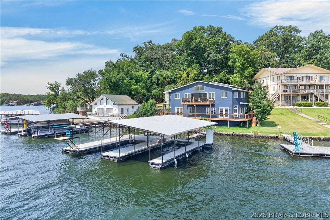 Turnkey, fully furnished, and currently operating as a successful nightly rental! Completely remodeled from top to bottom, this 7-bedroom, 4.5-bath lakefront home at the 4MM of the Gravois Arm is built for unforgettable weekends and strong investment potential. The spacious layout offers 2 kitchens and 2 living rooms making it ideal for large groups or multi-family living. Extensively remodeled over the last year to provide updated kitchens and bathrooms, new flooring, interior and exterior painting, drywall, insulation, lighting, plumbing fixtures, interior doors, and the addition of two bedrooms. Enjoy beautiful lake views from nearly every room, a flat yard and flat parking, plus an easy walk to the 2-slip dock. Seller is offering a $50,000 dock credit!!! Located in the same cove as Lake Burger and just around the corner from Jolly Rogers, it’s minutes from some of the lake’s favorite waterfront destinations while enjoying the protection of a cove. Whether you’re looking for an investment property, vacation home, or full-time residence, this one is truly move-in ready!