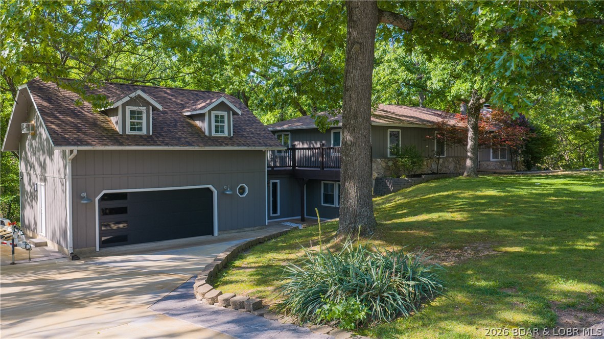 The ultimate family home just off Highway 54 in Linn Creek offers privacy, space & comfort on 1.6 acres. This updated property features 4 bedrooms, 2.5 bathrooms & a fully finished bonus space above the oversized two-car garage, ideal for an additional bedroom, apartment, office or recreation area. The garage is finished on both levels with epoxy flooring below & luxury vinyl flooring upstairs, plus separate HVAC systems for year-round comfort. Situated on a corner lot, the property offers a spacious backyard, large side yard & mature trees for a peaceful outdoor setting. Exterior updates include a new roof, fresh paint, new concrete driveway, updated deck railing & new decking on the wraparound deck. Inside, the large kitchen & dining area open to the living room with a wood-burning fireplace. Additional updates include opening the living room wall for better flow, updated basement stairwell, remodeled lower-level bedroom and family room & numerous other improvements throughout. All appliances are included. Located in a quiet subdivision within the Camdenton School District, just minutes from Osage Beach & Camdenton. Move-in ready with space for entertaining & everyday living!
