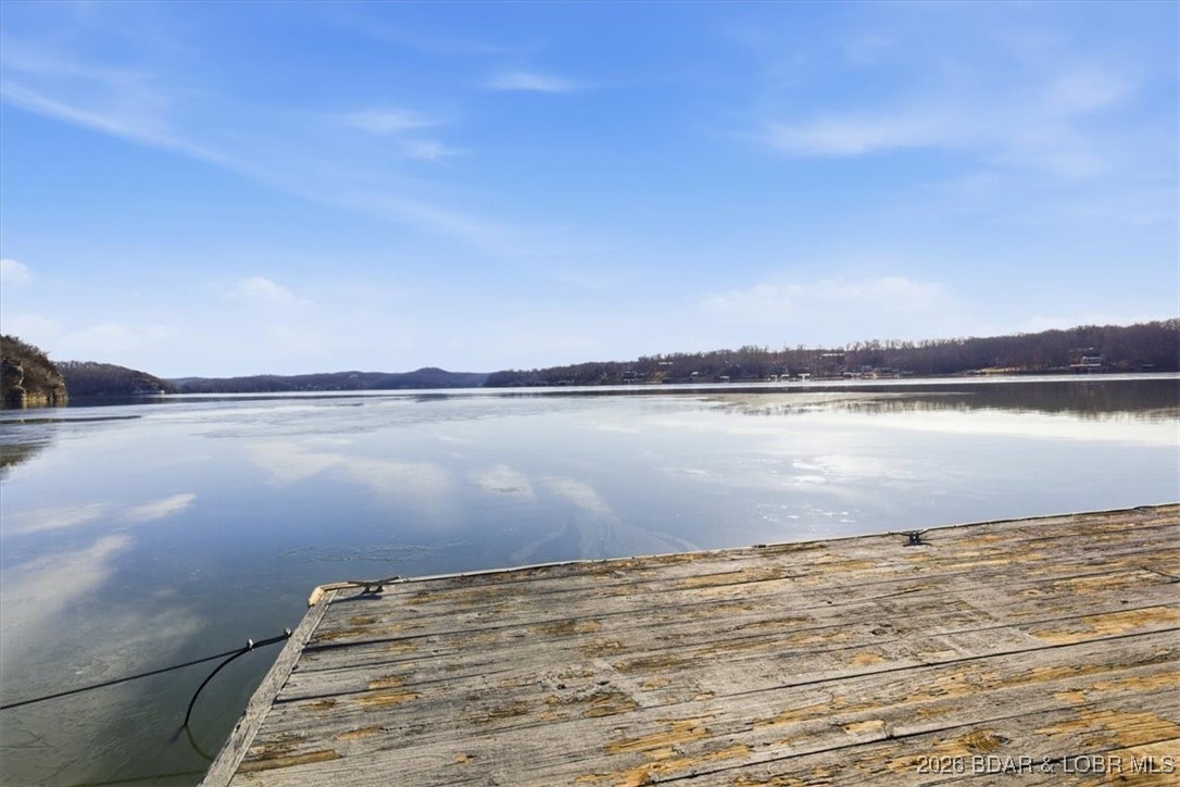 Get on the lake with this incredible 5.88-acre lakefront property offering over 300 feet of shoreline and stunning views. Enjoy a 54’ x 32’ dock with three boat wells, electric service, great water depth, and a storage shed ready to become the ultimate lakeside hangout. A 30’ x 40’ shop with concrete floors, three drive-in doors, and a roughed-in bathroom provides excellent flexibility—ideal for a shouse or future build support. Utilities include 50-amp service, wood stove venting, and AC accommodations. A 2019 Sportsman Toy Hauler currently sits on the prepared homesite with a rocked, well-maintained drive leading to the shop. Build now, enjoy the RV, or both—the choice is yours.  Don’t miss this rare lakefront opportunity—schedule your showing and step out onto the dock to take in the view.