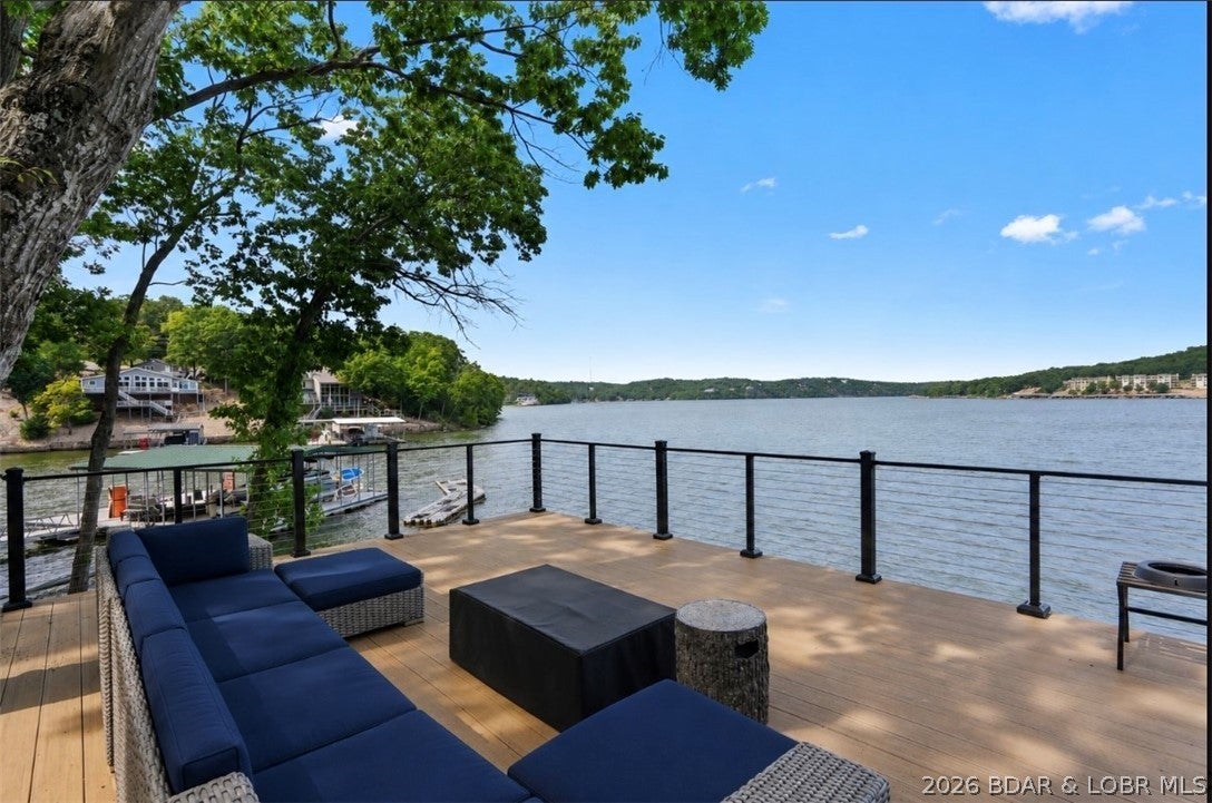 Lakefront living at the 24 MM in Stoneledge Estates with approximately 210 feet of shoreline, beautiful main-channel views and a detached bunkhouse with kitchenette. The 4-bedroom main residence offers an open kitchen and dining area, hardwood and tile flooring, vaulted ceilings, wet bar and brick fireplace. Newly updated bathrooms, Trex decking for low exterior maintenance and generous outdoor living spaces create an ideal setting for enjoying the lake. A covered 2-well dock with attached swim platform provides direct access to the water, while the semi-circular concrete driveway offers convenient parking. The detached bunkhouse adds flexible space for guests, a studio, or additional sleeping quarters and includes a kitchenette. Located just around the corner from Paradise Restaurant, this property combines substantial waterfront, main-channel views, a private dock and additional guest accommodations in one Lake of the Ozarks property.