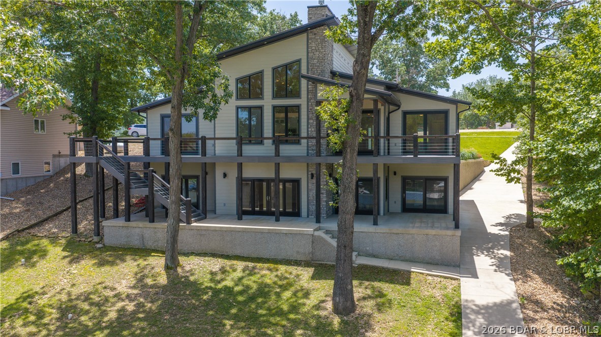 Experience Open Space Luxury lakefront living in this custom built masterpiece offering breathtaking main channel views and exceptional craftsmanship throughout. This stunning 5-bedroom, 4.5-bath home features rich hickory floors, soaring extra-tall vaulted ceilings, and energy-efficient 6-inch exterior walls with spray foam insulation. The chef's kitchen is designed for entertaining with Professional Series appliances, an oversized island, and seating for 12+ at the bar while comfortably accommodating gatherings of 20 or more. Unwind in the wine cellar complete with a humidor, or relax in the oversized family and entertainment room. Spacious bedrooms, including an oversized primary Ensuite, and custom bathrooms with heated floors provide luxurious comfort. Enjoy over 2,000 square feet of outdoor patio living overlooking the lake. Composite siding ensures low maintenance, while the gentle walk to the New private 2-well dock makes lake days effortless. A 3-car garage completes this one-of-a-kind Lake of the Ozarks retreat where luxury, comfort, and unforgettable views and memories come together. Best Value- New Custom Construction.