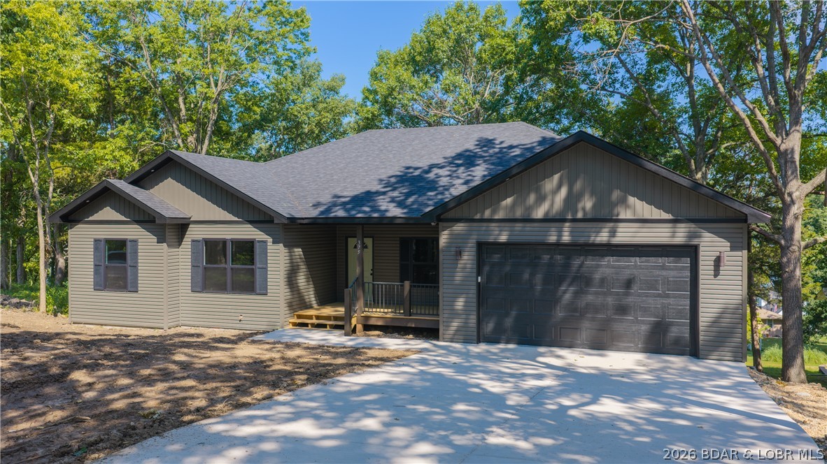Nestled in the beautiful Normac Estates on nearly an acre with an impressive 3,400 sq. ft. residence offers the perfect blend of privacy, comfort, and convenience. Enjoy the peaceful feel of country living while remaining just minutes from Camdenton, along with scenic lake views. The fully finished main level features four spacious bedrooms, including an oversized primary suite complete with a walk-in closet and convenient in-suite laundry hookups. Designed for everyday living and entertaining, the home also offers two full bathrooms, two laundry areas, and an open-concept kitchen, dining, and great room that flows seamlessly to both a covered front porch and a covered rear deck. The driveway provides abundant parking and easy access to the attached two-car garage, only two steps. The walk-out lower level is ready for your personal finishing touches, with the potential for two additional bedrooms, a full bathroom, a spacious family or game room, a covered patio, and ample storage. This home showcases attractive designer finishes, striking curb appeal, and a thoughtfully designed floor plan. This is a rare opportunity to own a brand-new home in the highly desirable Normac Estates.