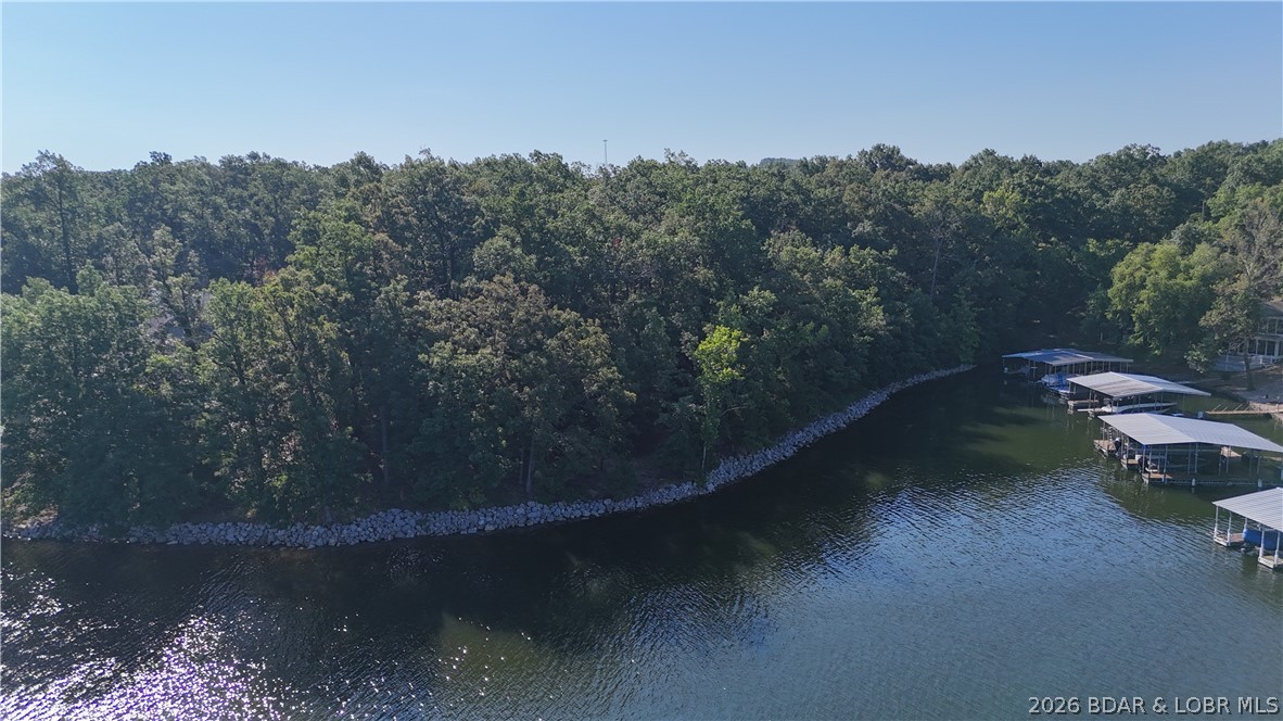 Seize this extraordinary & Rare Lakefront Opportunity with 440 ft. of shoreline and just under 2 Acres of Pure Potential (1.94 acres). You already have Rip Rap in place along with cove protection and a view at the 11 mile marker of the Osage.  It gets even better with No HOA and restrictions, providing unlimited possibilities.
Discover the perfect canvas for your lakefront legacy. It’s the ultimate setup for a family estate,  a primary residence with a guest house, or a high-end investment project. Being Short-Term Rental Friendly you can Capitalize on the growing demand for large-scale luxury vacation rentals. This lot has the perfect Terrain for luxury living where you are zoned to build 1 or 2 lakefront homes with a level driveway! Easy access to the main road and blacktop to your door. Whether you envision an infinity-edge pool, a lakeside fire pit, or sprawling outdoor entertaining spaces, this terrain can handle it all.  
Situated in one of the most desirable pockets of the Lake of the Ozarks, you get the best of both worlds with privacy yet easy access to local amenities. The photo of a home is an Artist Rendering through AI and not an actual home. Many possibilities.