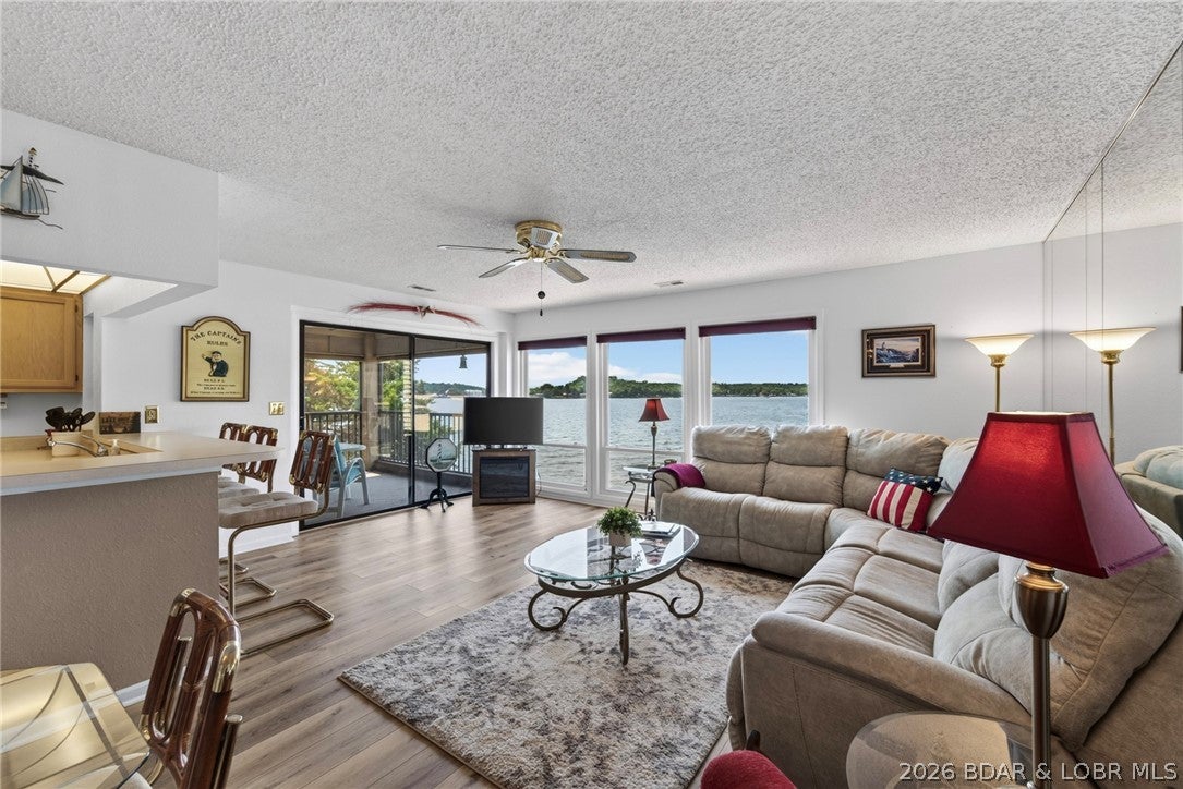 Immaculate waterfront condo with breathtaking, unobstructed main channel views! This beautifully maintained 2-bedroom, 2-bath unit features a large screened and carpeted porch with sunshades, perfect for enjoying the lake in comfort. The spacious master suite offers a sitting area, large walk-in closet and direct porch access. The well-appointed kitchen includes a breakfast bar and convenient pass-through window to the screened porch. Custom lakeside windows fold out for easy cleaning. Tastefully furnished with quality furniture and furnishings, this condo stands out from the typical package. Covered boat slip included. This exceptional Spinnaker Point unit is truly a must-see! Super strong HOA with plenty of reserves.