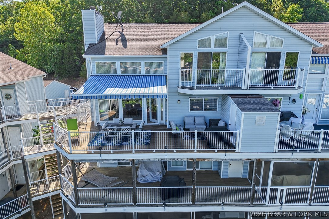 This is it—everything you've been looking for! Top Floor, Open-Floor Plan with Expansive Ceiling, Furnished, Garage, 2 Boat Slips with Lifts/Hoists (including one with a Captain's Call remote system), 3 sleeping rooms (2 bedrooms & Loft), and 2 full baths. This truly turnkey lakefront condo at Shores of Camelot in Libby Cove offers stunning lake views at the 2MM of the Niangua Arm. The open floor plan features soaring ceilings, a wall of windows, abundant natural light, a cozy fireplace, stainless steel appliances, and additional bar seating. The main level includes a bedroom, full bath, and laundry area. Upstairs offers a second bedroom with private balcony access, another full bath, and a loft-style third sleeping area for additional guests. Relax on the private deck with a retractable awning while enjoying beautiful lake views. Additional features include a garage, 5x10 storage closet, propane grill, and two boat slips with lifts. Community amenities include a swimming pool. Clean, well cared for, fully furnished, and ready for immediate lake enjoyment!