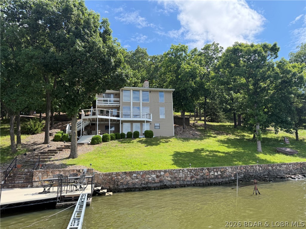 Discover the warmth and charm of this inviting turn-key lakefront home! Step inside to breathtaking lake views through expansive windows and admire the rustic wood accent ceiling that adds a cozy feel. The fully equipped kitchen is perfect for culinary enthusiasts, while the thoughtfully designed floor plan ensures privacy when you need it. The mid-level living area features a crackling wood fireplace, ideal for relaxing or making midnight snacks for night owls. With three spacious bedrooms on the upper level and a serene primary suite on the lower level, complete with a lakeside view, fireplace, and private deck access, you can truly unwind. Enjoy lakeside parking with a boat dock suitable for a cruiser or fishing boat, accompanied by a private breakwater for a peaceful lakefront experience. At the end of your day, savor your favorite drink under the stars on the new composite deck, complete with a tabletop firepit. This home is your perfect retreat, whether you're casting a line off the dock or cruising the lake. Don’t miss out on this serene getaway!