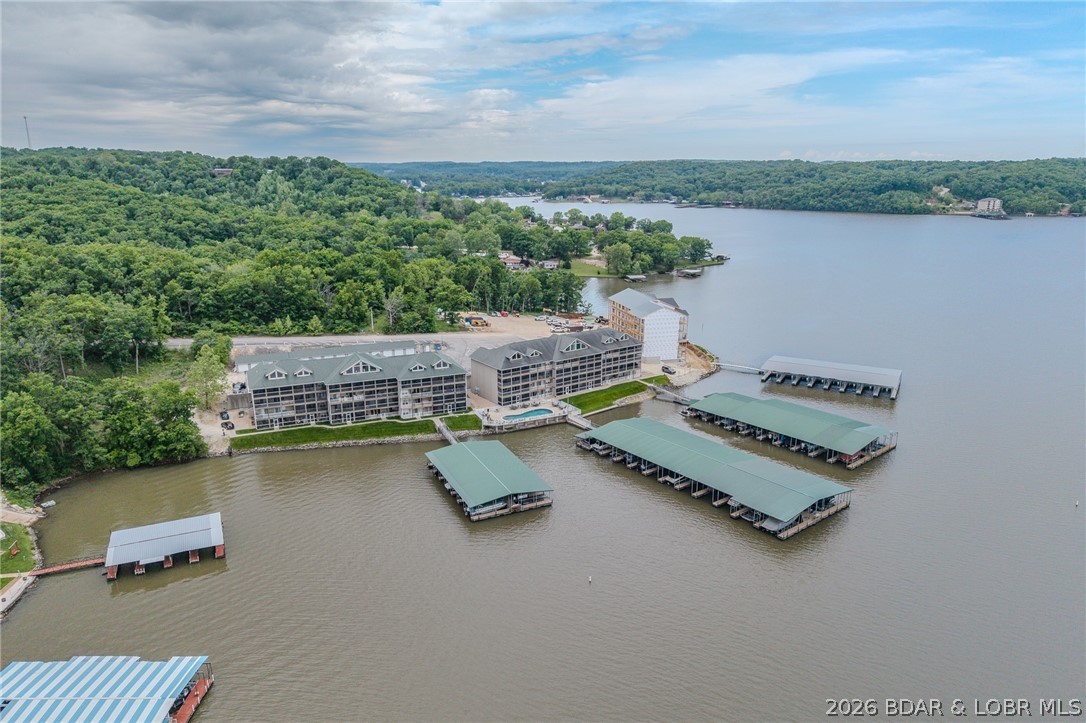 Check out this great Condo at the highly sought-after Miramar Complex! 3 bedrooms and 2 full baths, gives your family plenty of room to enjoy the lake. This complex is located directly across from The Cave Bar and Grill, so it has great access by water to lots of dining and entertainment! AND Highway 5 is just a few minutes away, giving you easy access to Camdenton, or Sunrise Beach, by land! The Condo comes turn-key, so it is ready to just walk in and enjoy! You will see that the large deck is well-furnished, with plenty of seating, table and chairs for eating, and even a refrigerator for your beverages. There is great fishing from the docks, and a beautiful pool to enjoy! If you like boating, you have a large 14 x 36 ft slip with a 6000 lb. hoist, and a PWC lift, that comes with this condo. So much to do and enjoy! You may just want to make it your permanent home! Home is under contract with a 72-hour kickout.  Please continue to show.  Offers still being accepted.