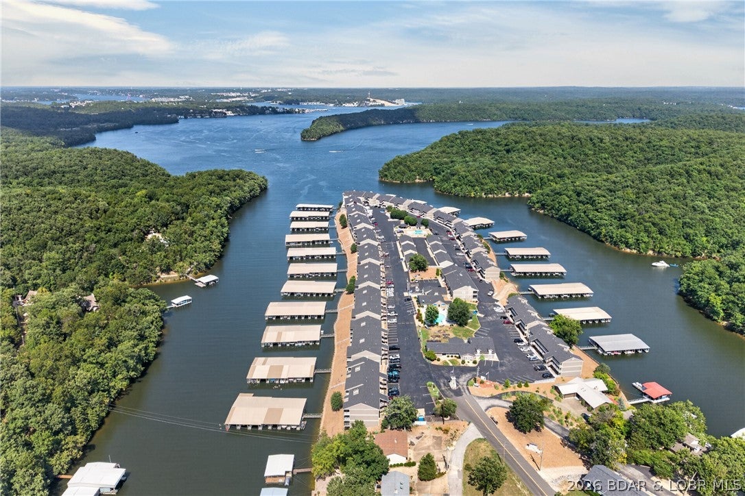 Highly desirable Lazy Days Condominium in the heart of Osage Beach! This tastefully decorated 3 bedroom, 2 bath condo comes fully furnished and completely turnkey. Inside you will find a spacious living area, large primary suite and plenty of room for family and friends. Step outside onto the oversized covered and screened in deck, complete with sun shades and a large storage closet. This east-facing unit makes it the perfect place to relax and enjoy comfortable evenings while taking in spectacular views of the state park and Grand Glaize Arm. Boaters will love the included 10x30 boat slip plus PWC space with lift, conveniently visible right from your deck. Owners and guests are permitted to swim right off the dock a rare amenity among condo complexes! Lazy Days is meticulously maintained and offers fantastic community amenities, including two beautiful swimming pools, playgrounds, grilling area, boat ramp,and trailer parking. Ideally located close to restaurants, shopping, and all the lake area attractions. Whether you're searching for your own Lake of the Ozarks getaway or an investment opportunity, this beautiful condo checks all the boxes. Come enjoy lake life without the work!