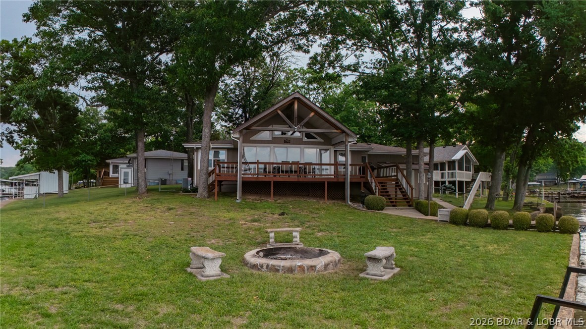 Lakefront living at its finest in this stunning waterfront ranch home, perfectly positioned on year-round deep water with panoramic views of the Lake of the Ozarks. Sunlight pours into every room, offering breathtaking lake vistas and unforgettable sunsets from nearly every angle. Beautifully maintained, move-in ready featuring two spacious bedrooms and two full bathrooms, with an open-concept floor plan designed for effortless entertaining. The four-seasons sunroom invites you to start your day with morning coffee as you watch the sun rise over the water in this eastward-facing retreat. Enjoy the ultimate in outdoor living with a wrap-around deck, ideal for gatherings or peaceful evenings overlooking the lake. Boating enthusiasts will appreciate the three-slip covered dock, complete with three lifts, a swim platform, and a diving board—perfect for summer fun with family and friends. Storage and flexibility are unmatched, with both attached and detached garages, as well as a charming “she shed” for all your hobbies and gear. Most furnishings are included, making this an easy turnkey opportunity—just bring your suitcase and start enjoying lake life right away. Priced at $659,900