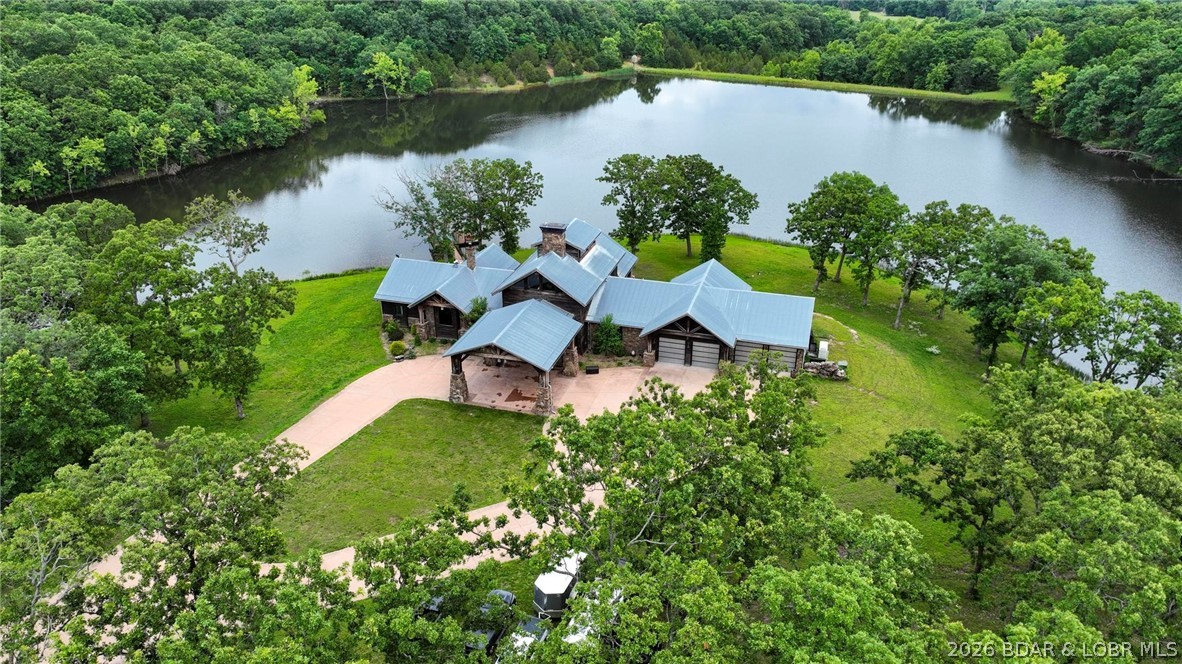 Tucked away on 267 breathtaking acres, this luxury estate offers an ultimate retreat with the rustic elegance of an upscale mountain lodge. Built in 2018, the timber frame post-and-beam main home features over 7,300 sqft. overlooking a 20-acre private lake, a 922-sqft. 2 bedroom guest house was added in 2023. The main home has soaring 31' vaulted ceilings, massive timber beams, and a dramatic floor-to-ceiling wood-burning stone fireplace creating a warm gathering space. The primary suite features its own stone fireplace, lake views, and separate his-and-her walk-in closets.  In total, the property offers 6 bedrooms. The lower level includes 2 additional bedrooms, a bunk room that sleeps 10, theater room, secure safe room w/ thumbprint lock, elevator access, and a workshop/gun/ammo room off garage. Guest house features 2 private en-suite bedrooms overlooking the woods, providing ideal accommodations for family and guests. Outside, enjoy endless opportunities for fishing, boating, and peaceful sunsets on the private lake with boat dock. Every detail was designed to showcase craftsmanship, comfort, and the beauty of the landscape, creating a truly one-of-a-kind estate or forever home.