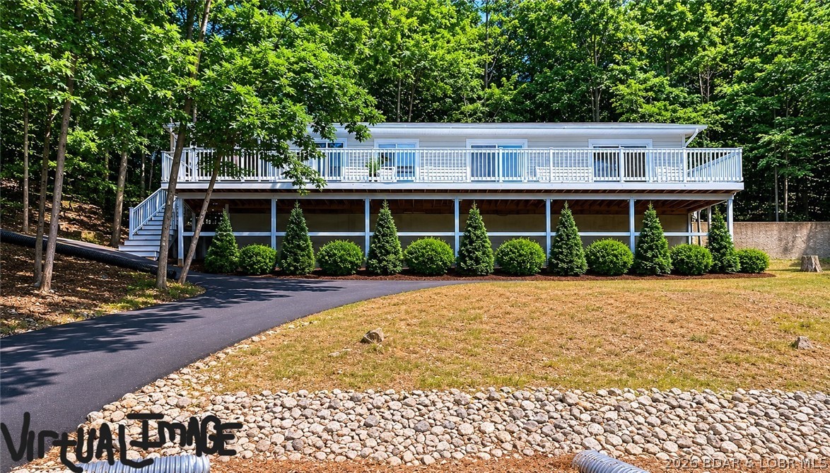Invest in your future- this affordable 2 BR/2B home sets on a private double lot & is situated w/ seasonal views of Lake of the Ozarks. Remodeled w/ functionality & ease in mind, the home boasts luxury vinyl flooring, quartz surfaces, new appliances, modern bathrooms & cabinetry- including a large primary walk in shower. The wrap around drive, shares more privacy & function as your main entrance is weather protected; the large tree filled lot provides seclusion & future expansion shall you desire. The lakeside deck expands the length of the home, w/ access from the kitchen & bedroom entrances. Additional upgrades to the home include a new asphalt drive, new concrete pad in the covered carport, new aluminum fascia/guttering/leaf guards, landscaping rock & tree trimming, & professionally painted deck- over $100,000 of improvements! The home offers the exclusive Four Season amenities- community center w/ activities & classes, fitness facility, indoor/outdoor pools, dog park, hiking & biking trails, tennis courts, pickleball, playgrounds, camping grounds, boat ramp & trailer parking. Modern appeal, move in ready, main floor living needs, or annual rental- schedule your showing today!