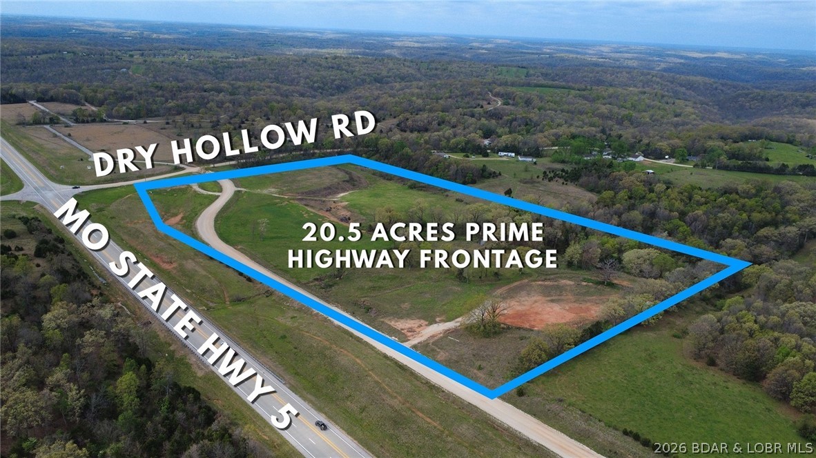 Developers and investors — take notice. This 20.57-acre tract just 3 minutes south of Camdenton along State Hwy 5 at Dry Hollow Rd is strategically positioned for commercial or residential type development. Located outside city limits, the property offers flexibility for a wide range of uses beyond the norm. The level terrain supports efficient site development, and highway frontage provides excellent visibility and access for operations such as a UPS distribution hub, shop rental complexes, contractor yards, equipment dealerships, concrete or asphalt facilities, or other ventures like a residential neighborhood. 
Public water is located across Dry Hollow Rd and electric is at the edge of the property, helping streamline utility planning. A pond on the property adds functional water access and site character. With no HOA restrictions and strong regional connectivity on the State Hwy 54 and even I-44, this parcel presents a rare opportunity for scalable development in a strong growth corridor with high traffic exposure. Seller would consider selling 4 acres on north end build site separately. Call or text for more information!