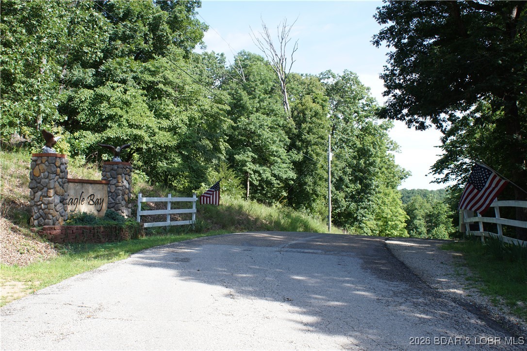 Here is one of the best kept secrets of Lake of the Ozarks. Eagle Bay is a beautiful community with incredible views, Paved roads throughout, park-like setting, water/sewer to every lot. This part of the lake is very quiet and peaceful, just 20 minutes from Laurie sits a lot with 111 feet of Lakefront and not far from a community dock. You can also have your own private dock as well. The panoramic view, large cove location, serenity and beauty is what makes this lot so inviting. A home with a lower-level walkout would be prefect for this location, lot can be made to have easy accesses to the lake and a concrete path for a golf cart to the water's edge would be a great way to your own private boat dock. A development like this, on the quiet side of the Lake, is very hard to find. This lot and community is a must see, you will be amazed how wonderful this location is with its great views of the Lake.