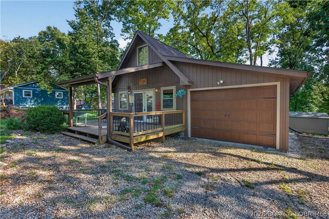 Beautiful 2-bedroom A-frame located in one of the most desirable neighborhoods near Truman Lake! Situated in Sterett Creek, this home offers a spacious lot, attached garage, and a large partial wrap around porch perfect for relaxing and enjoying the outdoors. Inside, you'll find beautiful wood flooring throughout the main level and an inviting living room and kitchen area. Enjoy convenient main-level living with an additional loft upstairs offering flexible space for guests, an office, or recreation area. Paved roads lead all the way to the property, and neighborhood amenities include access to the community pool and pavilion. Just a golf cart ride from Unhitched Sterett Creek Marina and restaurant and only about 5 minutes from Warsaw, this is a great opportunity for a full-time residence or Truman Lake getaway!