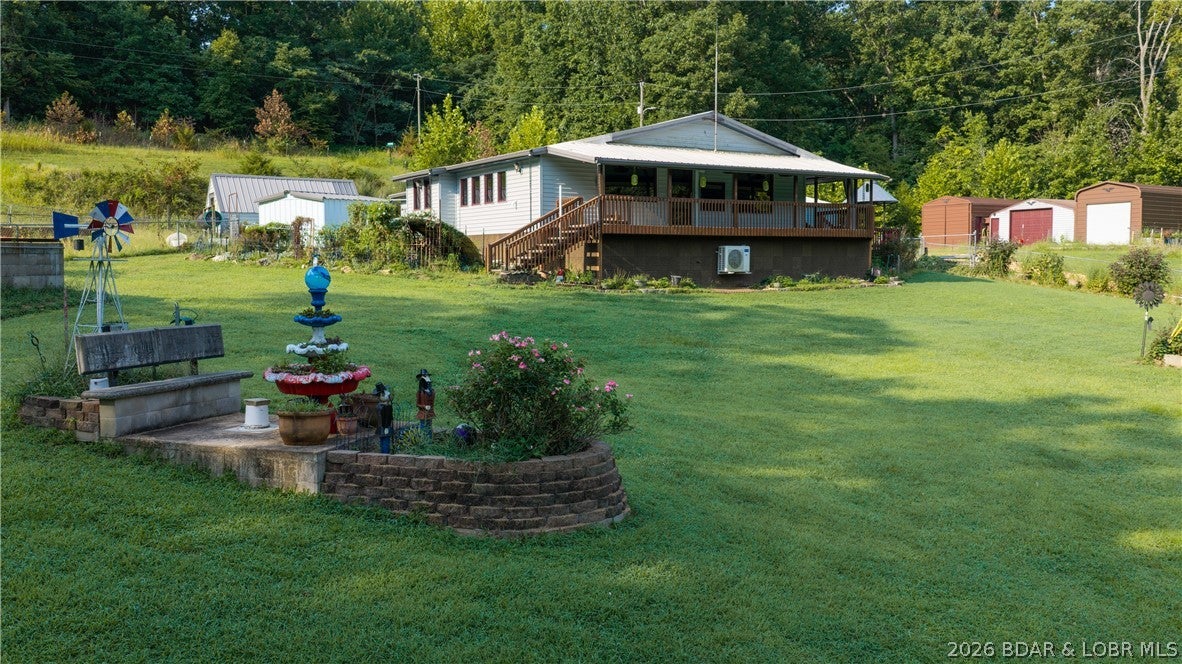 A little acreage, a little Lake life and a whole lot of space to make your own! So much love & life has been poured into this home as current owners have been there for over 25 years. It is even prettier in person. This 2-bedroom, 1-bath home brings together a wooded setting, open ground, lake access and an impressive lineup of extras. Inside, you’ll find vaulted wood ceilings, extensive woodwork, a fireplace and an open kitchen with an oversized island, stainless appliances and abundant cabinetry. Storage is everywhere here, with built-ins and cabinetry throughout the home and even more waiting outside. The spacious bathroom features a private sauna along with a convenient stacked washer/dryer. A large covered porch overlooks the yard, while multiple detached garages and outbuildings give you room for vehicles, boats, equipment and just about everything else. Add dedicated workshop space, a storm shelter, usable open acreage and the privacy of the surrounding woods, and you’ve got a property with room to live, work, store, create and enjoy the Lake—all from one place. Public boat ramp is just down the road. Patriot's Point is near by if you need dock space. Fire Dues $75 per year