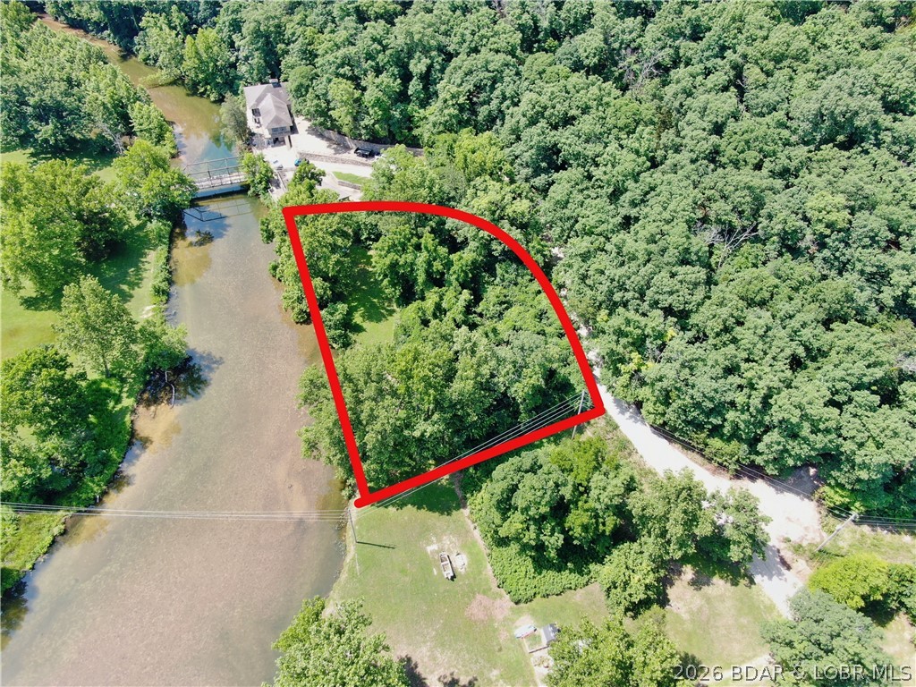 Discover a one-of-a-kind waterfront property offering the perfect blend of natural beauty, privacy, and development potential. This 0.70-acre riverfront lot sits along the crystal-clear, spring-fed waters of the Bank Branch River, nestled within the breathtaking surroundings of Ha Ha Tonka State Park. Exceptional water clarity, outstanding fishing, and direct access to nature from your own backyard. Catch fish right off the shoreline. Small boats, kayaks, and canoes can easily access the Lake of the Ozarks from the property, ideal location for both relaxation and adventure. The existing lot is approved for construction of up to a 3-bedroom home. Sale includes access to a 0.75-acre utility lot, with opportunity for an additional well and septic system that can accommodate a larger home. A home built above the 668-foot elevation does not require flood insurance,  a 15-foot river access easement for upper lots located along the far north edge of the property. Dreaming of a full-time residence, a vacation retreat, or investment in one of the Lake area's most scenic settings, this property offers the opportunity to own riverfront land in one of Missouri's beautiful natural destinations.