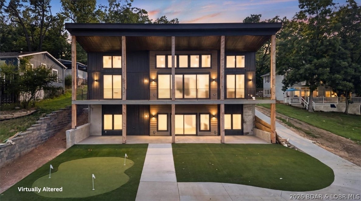 Every inch of this brand-new 2026 custom home was designed to impress—from the striking architecture and soaring wood ceilings to walls of glass framing incredible main channel views! The kitchen was built to entertain with a massive waterfall island that seats 8, custom cabinetry with a built-in dining nook, commercial-grade refrigerator, and an impressive walk-in butler's pantry. The primary suite is pure luxury, featuring a spa-inspired bath with a freestanding soaking tub inside the oversized walk-in shower, a spacious walk-in closet, and an oversized main-level laundry room with hookups for two sets of washer/dryer. The lower level offers a second living area with a bar, 4 beds, 2 baths, and storage. Step outside to the covered deck and patio with ZERO steps to the water! Enjoy a turf yard for low maintenance, plus a putting green and fire pit for endless lake days! Whether you're hosting friends and family or looking for a rental investment, this home was built for luxury lake lifestyle. Spray foam insulation, tankless water heater, metal roof, Hardie siding, fiber internet, paved driveway, and exceptional craftsmanship throughout! Custom dock available for additional cost.