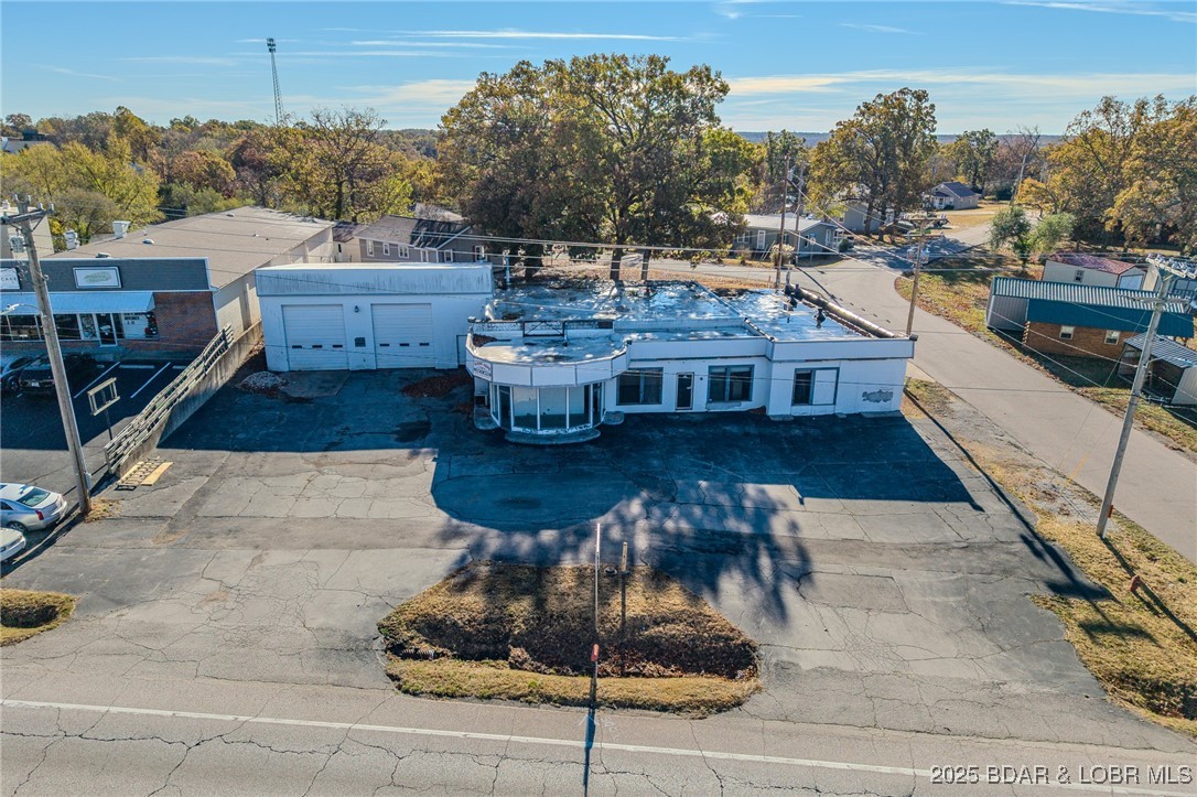 Camdenton, MO. Very Enticing 125 Ft Highway Frontage + 254 Side Street Frontage on W Highway 54 just 3-4 Blocks from a growing Town Square. WOW! Traffic Count is 16,549 Vehicles per Day. Great Visibility with Easy Access. On a 0.373 Acre Corner Lot which Includes a Commercial Approx 6,438 SqFt Building on Level Land with a Large Parking Lot & the Back Flat Vacant Parcel which could be used for Additional Parking or Building Expansion is available for RENT. Formerly an Auto Garage/Station (See completed DNR Phase 2 Tank Removal Reports in attachments). So Many Possible Uses: Retail, Office Building, Auto or Marine Garage/Sales, Restaurant, Medical, Rental Property, Supply Storage Building, etc. Commercial Building includes: Large Reception Area, Glass Atrium Display Room, Large Office Area, 3 Different Shop Areas with 3 Large Commercial Garage Doors, Storage Areas, Sump Pump, Drains in Floors of Shop Areas. (Back Wall needs some Work- see Foundation Recovery BID in attachments). Ceiling Heating Units have been removed from all 3 shops. Zoned Commercial. Great Opportunity & Great Location. *You Must See the Extra Feature Sheet in Listing Attachments for much more additional info*
